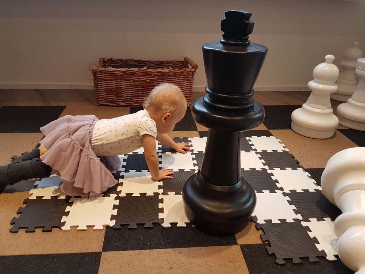 2 year old girl discovering a big chess board