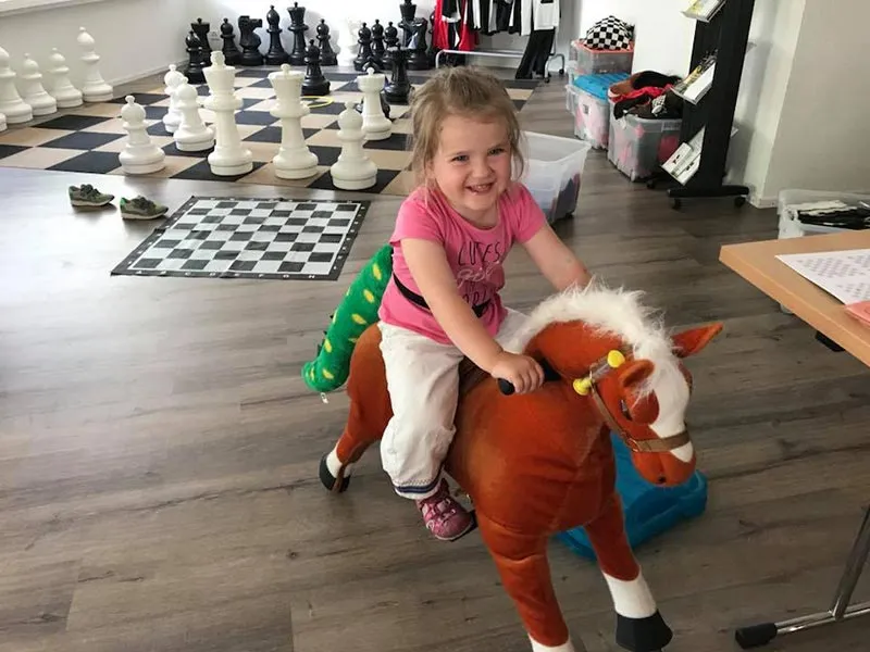 Kleines Kind reitet auf Spielzeugpferd